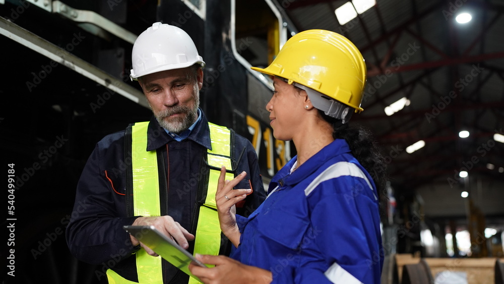 Group of apprentices with instructor at railway engineering facility. Teacher talking to apprentices at railway engineering facility Group of apprentices with instructor at railway engineering facility. Teacher talking to apprentices at railway engineering facility
