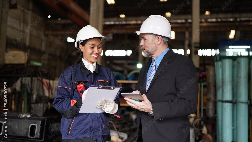 Factory manager or businessman and female engineer in factory. elegant man inspecting factory in industry plant background. Factory manager or businessman and female engineer in factory. elegant man inspecting factory in industry plant background.
