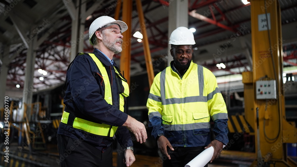 Portrait of engineer and apprentice in workshop of railway engineering facility Portrait of engineer and apprentice in workshop of railway engineering facility