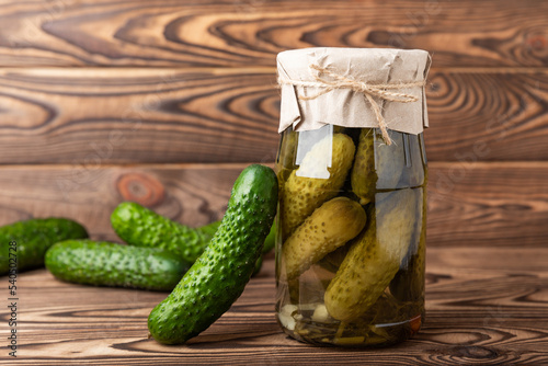 A jar of pickles. Canned cucumbers in a jar on a brown wooden background. Collection of vegetables. Pickled jars. Stocks for the winter. home preservation. pickles. Copy space