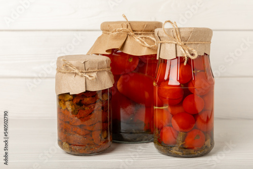 Pickled tomatoes and sun-dried tomatoes in a jar on a white wooden background. Food supplies. Healthy food. Harvesting. copy space. Place for text.