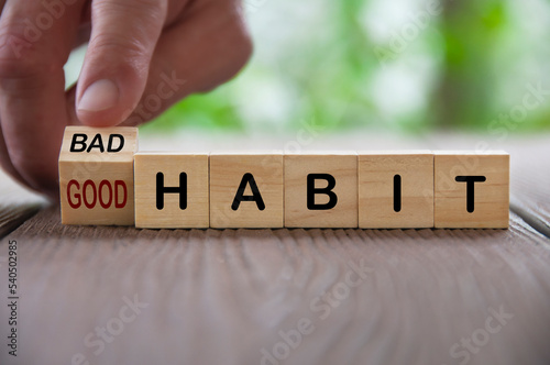 Finger turning bad and good text on wooden blocks. Good and bad habit concept
