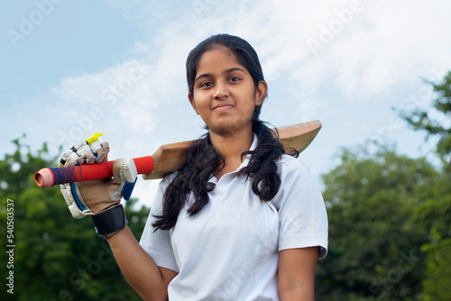 Portrait Of A Female Cricketer Holding A Cricket Bat
