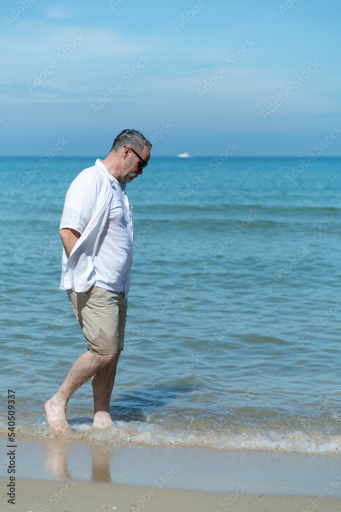 Foreign tourists stroll along Asia's beautiful blue sea beach.