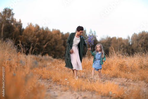 Mother with daughter walking on a road