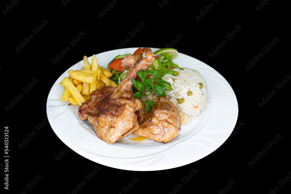 Grilled chicken chops with rice, salad and french fries in a white plate