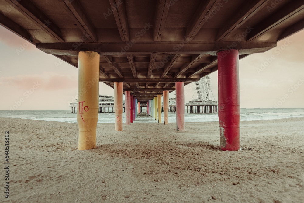 Breathtaking detail of colorful pillars under the The Pier at Scheveningen, The Netherlands. The Pier and The Ferris Wheel at Scheveningen. Concrete bridge pillar view for construction.