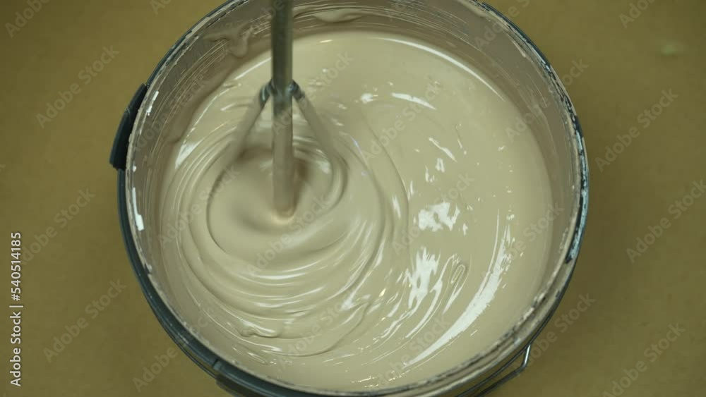 The process of mixing paint in a bucket before applying it to the walls