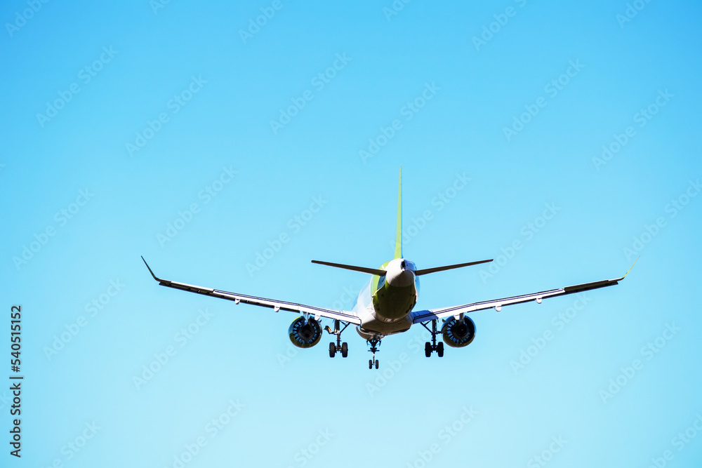 An airplane flying in the lighht blue sky without any clouds