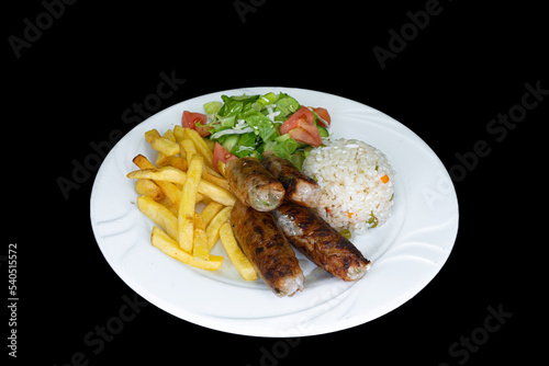Grilled chicken sheftali with rice, salad and french fries in a white plate