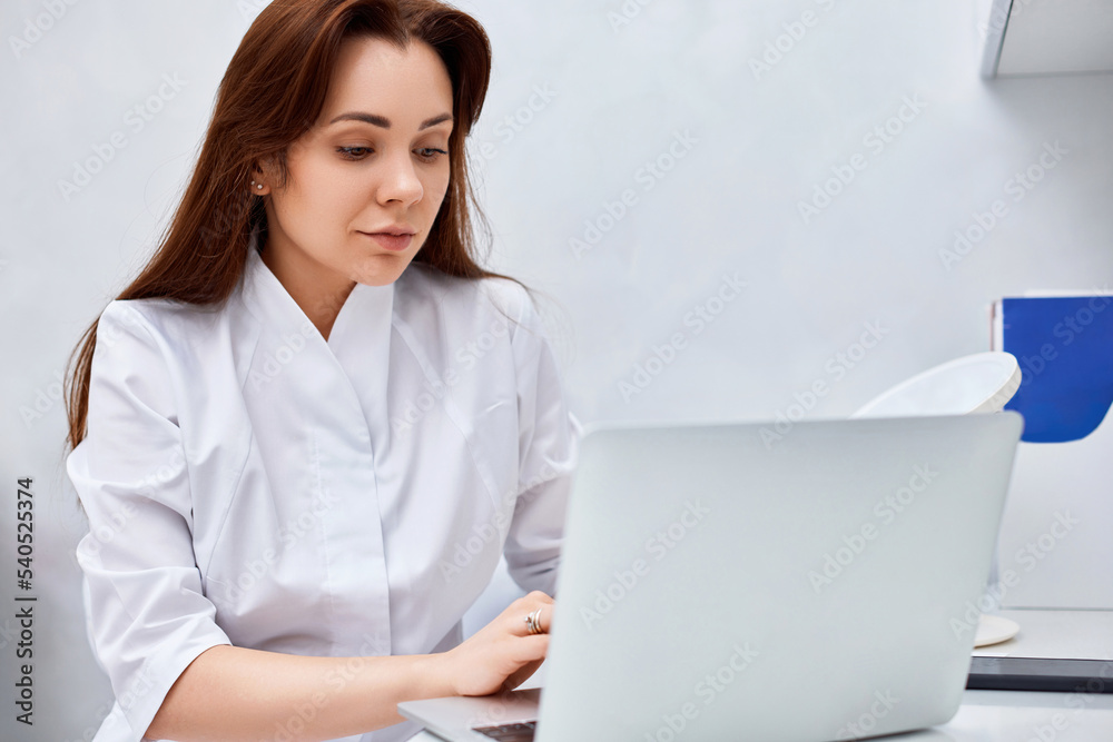 female doctor in white medical uniform using laptop female doctor in white medical uniform using laptop