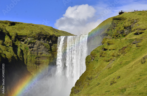 Splashes, water and a rainbow at the Skógafoss waterfall close up in Iceland on a summer sunny day