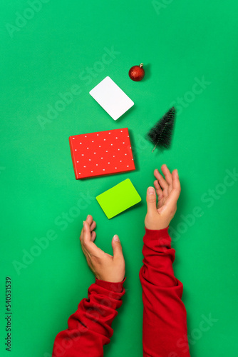 Minimal flat lay of bonus card templates, gift box and christmas objects in female hands