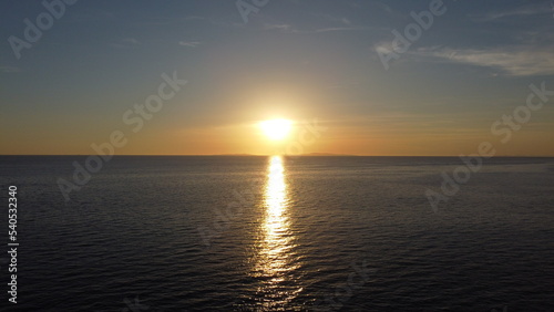 A beautiful sunset that spreads its rays on the calm surface of the ocean