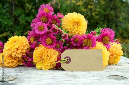 Greeting card with a bouquet of autumn flowers with yellow dahlias and pink asters