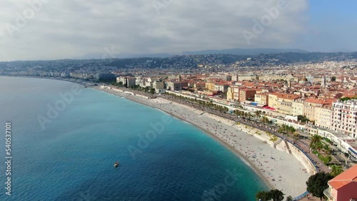 Beautiful panorama of English Promenade in Nice, France. Palm trees, old houses in Old Town Azure Sea And Green Hills. Summer in French Riviera. View from sky, Drone video 