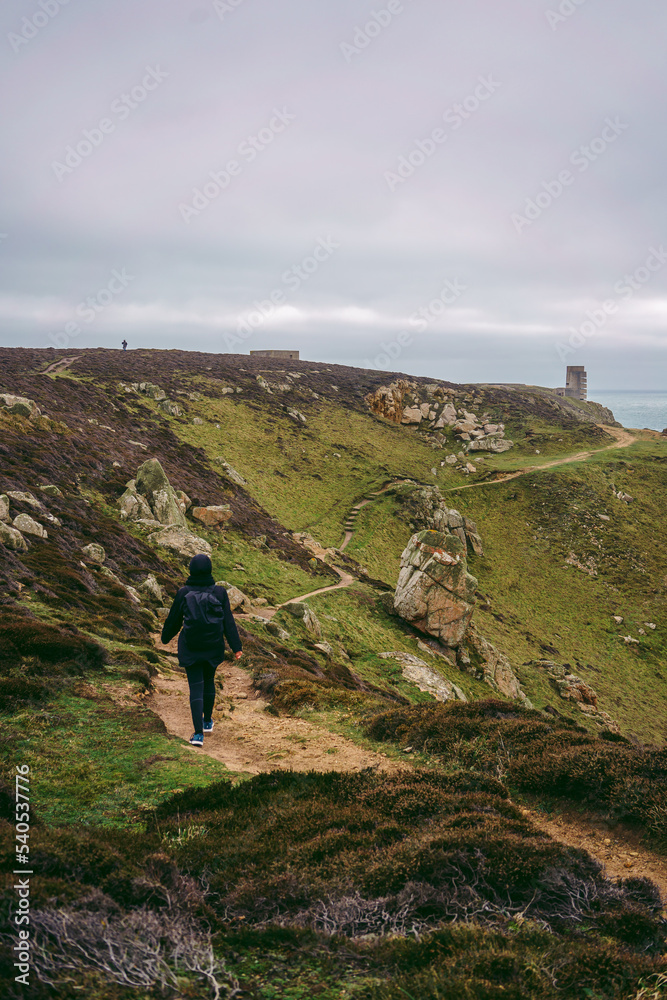 Hiker going down the path on the Jersey island UK