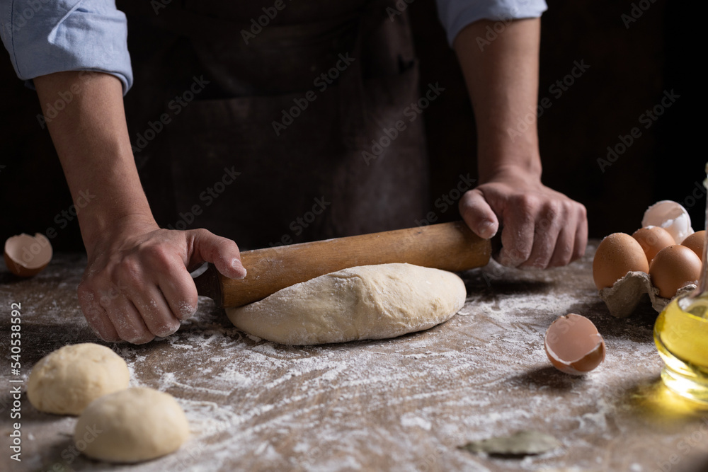 Baker chef man kneading dough bread and bakery ingredients for homemade cooking at table Baker chef man kneading dough bread and bakery ingredients for homemade cooking at table