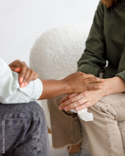 mental support to hold hands  handshake. An African-American female psychologist holds an appointment with a patient in the office. mental health and moral support. a female patient with mental