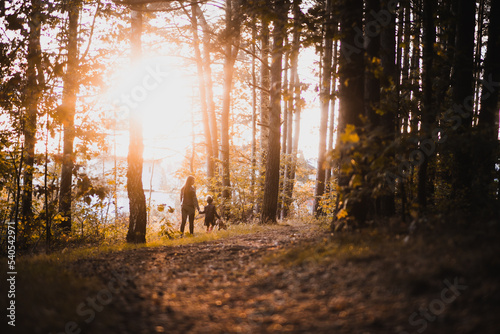 Mama i córka na spacerze o zachodzie słońca słonecznym lesie