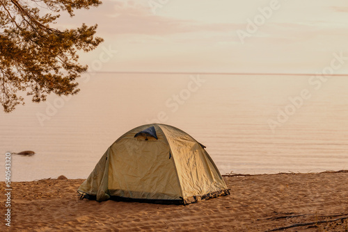 tent in nature on the shore of a lake or sea. vacation travel and weekend solitude. a trip out of town to wild places, tourism and recreation for a traveler and an altpinist. spend the night in an