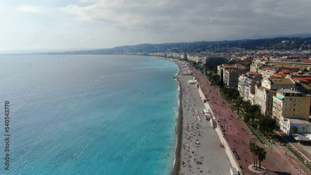 Beautiful panorama of English Promenade in Nice, France. Palm trees, old houses in Old Town Azure Sea And Green Hills. Summer in French Riviera. View from sky, Drone video Beautiful panorama of English Promenade in Nice, France. Palm trees, old houses in Old Town Azure Sea And Green Hills. Summer in French Riviera. View from sky, Drone video