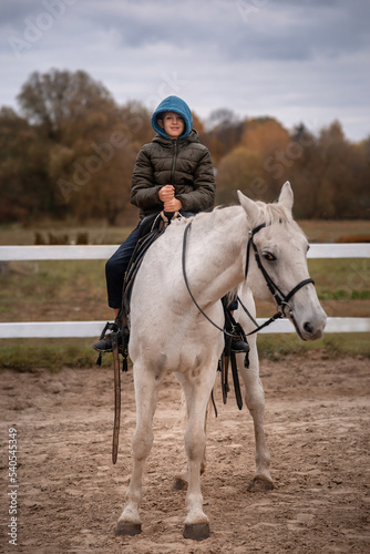 boy is riding a white horse © Olena
