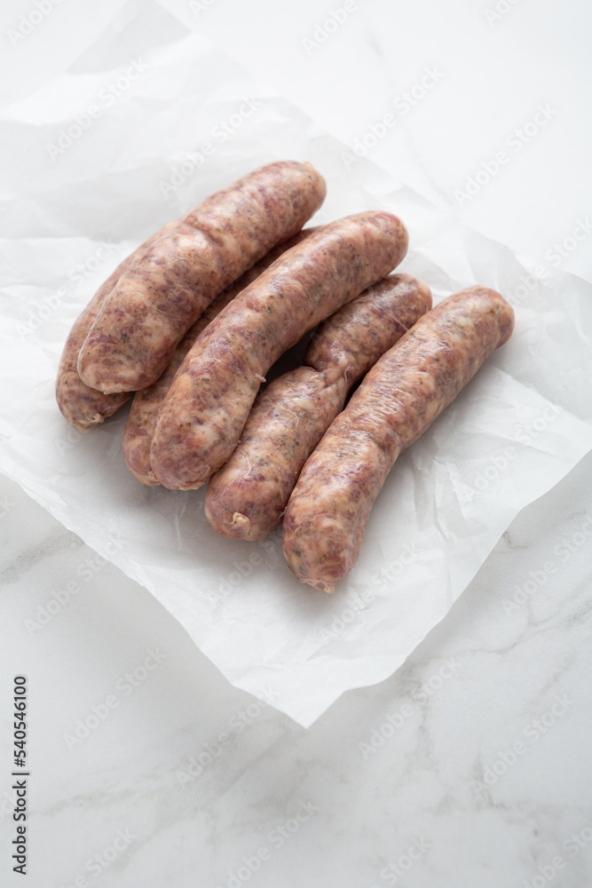 Uncooked barbeque sausage on packing paper cooking food Uncooked barbeque sausage on packing paper cooking food
