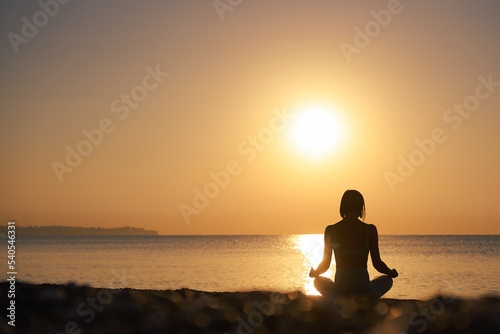 Silhouette young woman practicing yoga on the beach at sunset  Karon Beach  Phuket  Thailand. For background and texture. High quality photo