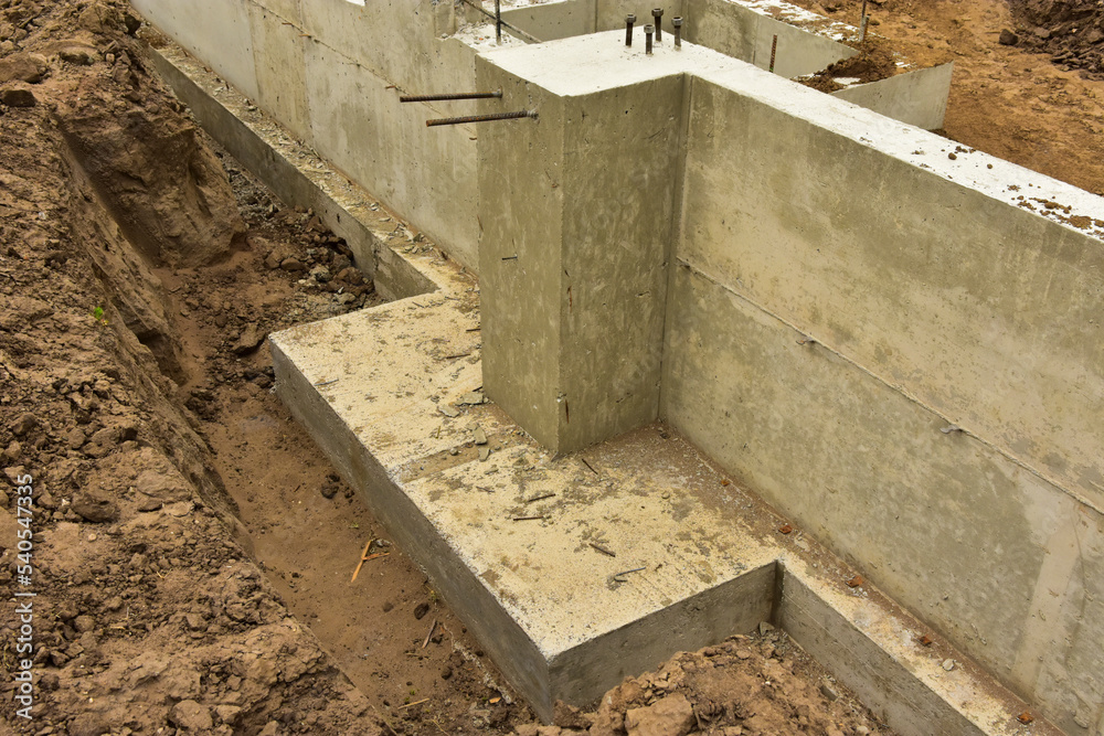 Concrete footings and foundation with anchor bolts ready for further