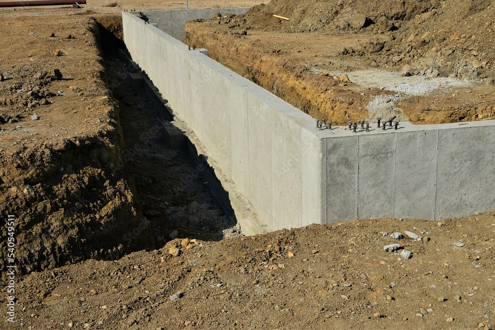 Concrete footings and foundation with anchor bolts ready for more