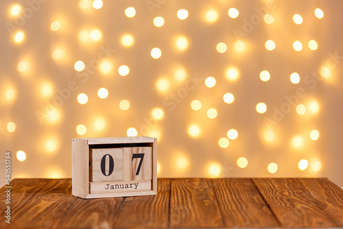 christmas, wooden calendar january 7 on wooden background and lights background