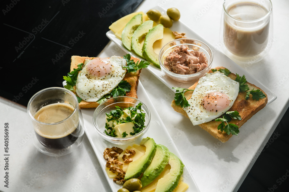 Fried egg with toast, parsley, sliced avocado, butter on a white plate. Morning breakfast. Top view. Fried egg with toast, parsley, sliced avocado, butter on a white plate. Morning breakfast. Top view.