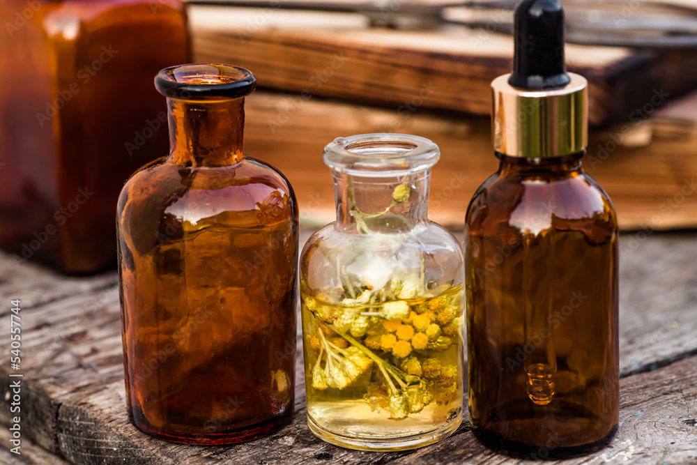 july arenarium, helichrysum arenarium, dwarf everlast, immortelle, curry plant, italian strawflower apothecary bottles with tincture and essential oils for beauty salons and alternative medicine. july arenarium, helichrysum arenarium, dwarf everlast, immortelle, curry plant, italian strawflower apothecary bottles with tincture and essential oils for beauty salons and alternative medicine.