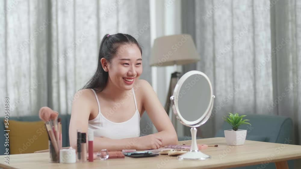 Beautiful Young Asian Woman Looks In The Mirror Using An Eyelashes Curler And Smiles While Applying Makeup At Home
Beautiful Young Asian Woman Looks In The Mirror Using An Eyelashes Curler And Smiles While Applying Makeup At Home