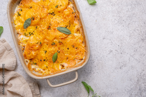 Savory Sweet potato gratin with cream and cheddar cheese in baking dish