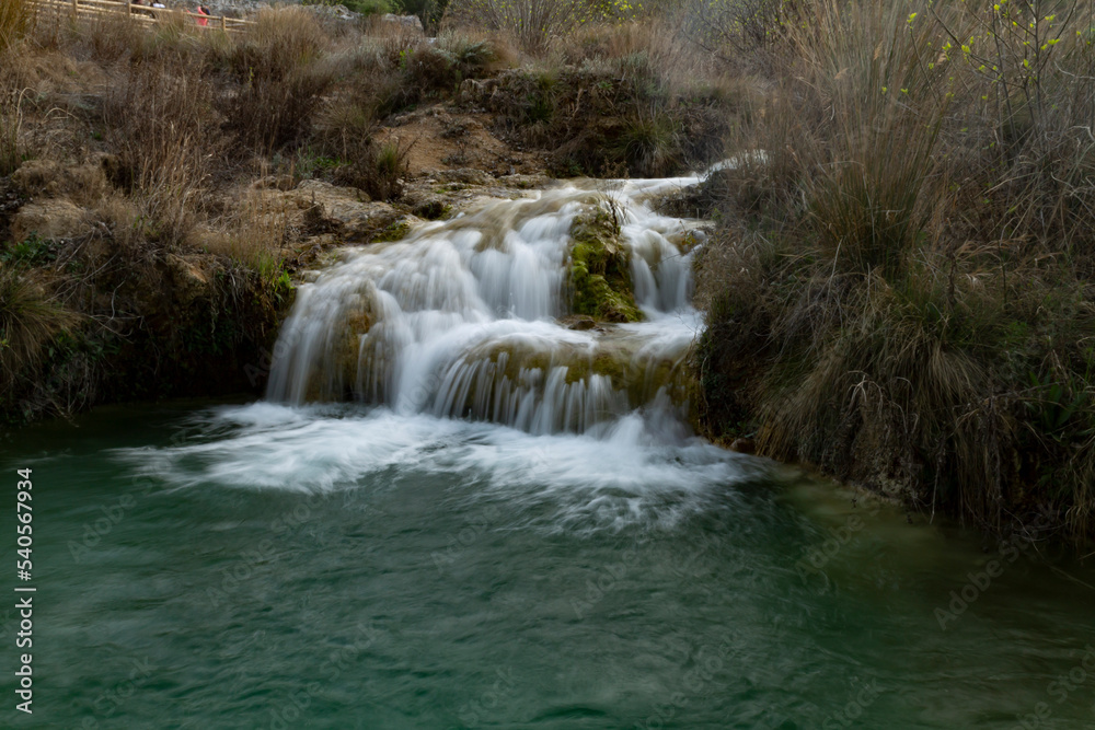 waterfall with silky effect in waters of turquoise and green tones in lagoons with trees and bushes in autumn tones waterfall with silky effect in waters of turquoise and green tones in lagoons with trees and bushes in autumn tones