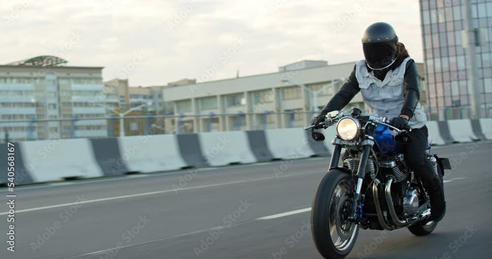 Driving Bike on Streets. Speed Motion in Cityscape. Fast TRACKING Shot of a biker riding his custom built cafe racer through city. Motorcyclist Drives on Motorcycle on Road. Slow motion 60 fps Driving Bike on Streets. Speed Motion in Cityscape. Fast TRACKING Shot of a biker riding his custom built cafe racer through city. Motorcyclist Drives on Motorcycle on Road. Slow motion 60 fps