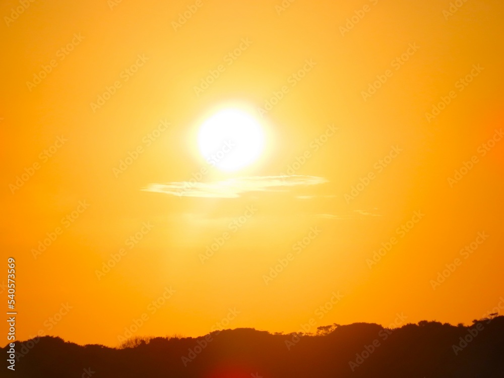 Por do sol com céu alaranjado em uma tarde de verão na Barra do Una, Peruíbe, São Paulo