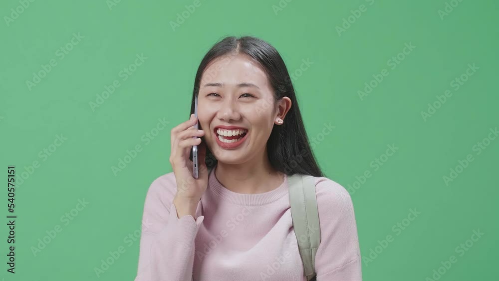 Happy Asian Woman Student Talking On Mobile Phone While Walking On Green Screen Studio
Happy Asian Woman Student Talking On Mobile Phone While Walking On Green Screen Studio