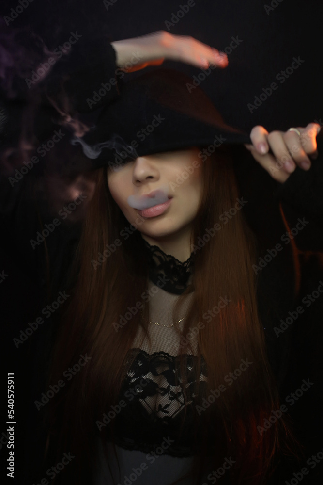 portrait of a beautiful young red-haired girl on a dark black background in the studio, with a cleavage and big breasts in black hoodie lets out smoke, smokes portrait of a beautiful young red-haired girl on a dark black background in the studio, with a cleavage and big breasts in black hoodie lets out smoke, smokes