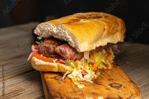 choripan chorizo sandwich on bread with vegetables and chimichurri