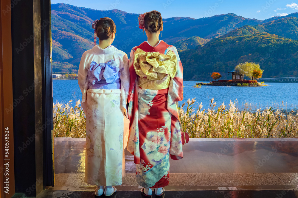 Geisha from Japan. Lake Kawaguchiko. Geisha woman with their backs to camera. Girls admire nature Japan. Geishas look at gazebo in lake Kawaguchiko. Japanese traditions. Nature before Japanese island