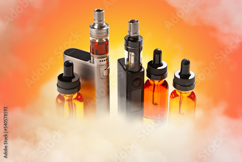 Electronic cigarette. Vape pens with refill liquids. Concept of selling liquids for electronic cigarettes. Vape pens in smoke. Vaper kit. Vape pens on orange. Tobacco-free vaping kit