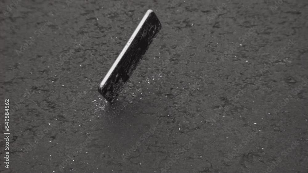 Smartphone falling onto pavement in 1000fps slow motion; broken cell phone theme
