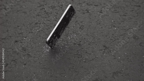 Smartphone falling onto pavement in 1000fps slow motion; broken cell phone theme