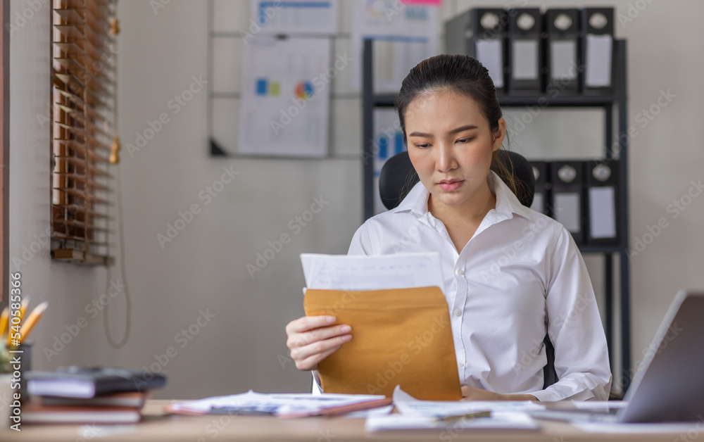 Young business Asian woman stressed while working, Tired asian businesswoman with headache at home office, payment stressed and confused by calculate expense from invoice or bill tax. Young business Asian woman stressed while working, Tired asian businesswoman with headache at home office, payment stressed and confused by calculate expense from invoice or bill tax.