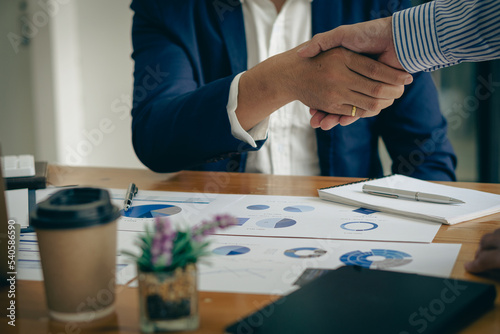 Young businessmen shaking hands in the office Completing a successful meeting of teamwork, cooperation and handshake greetings