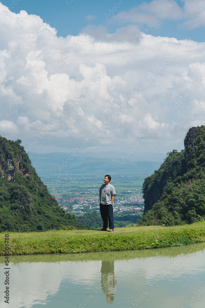 A man stand alone to relax on the field, range of mountain background, for wallpaper travelling A man stand alone to relax on the field, range of mountain background, for wallpaper travelling