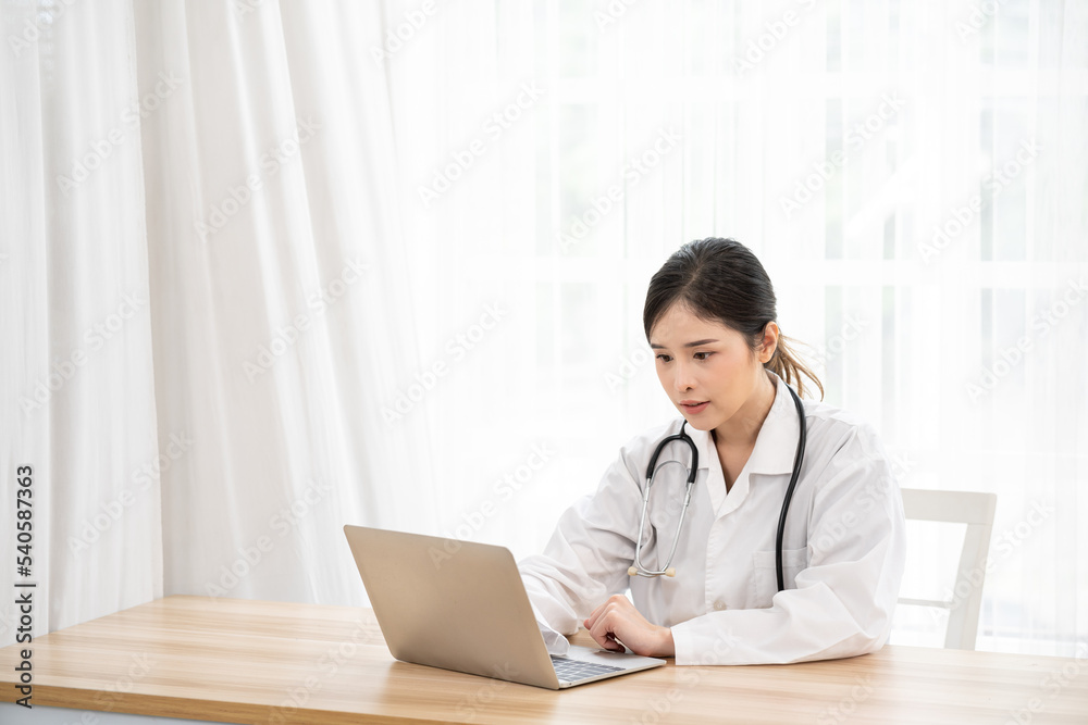 Asian female doctor using laptop computer online video call remote talking to patient. Medical practitioner giving online virtual consultation to patient from hospital office. Asian female doctor using laptop computer online video call remote talking to patient. Medical practitioner giving online virtual consultation to patient from hospital office.